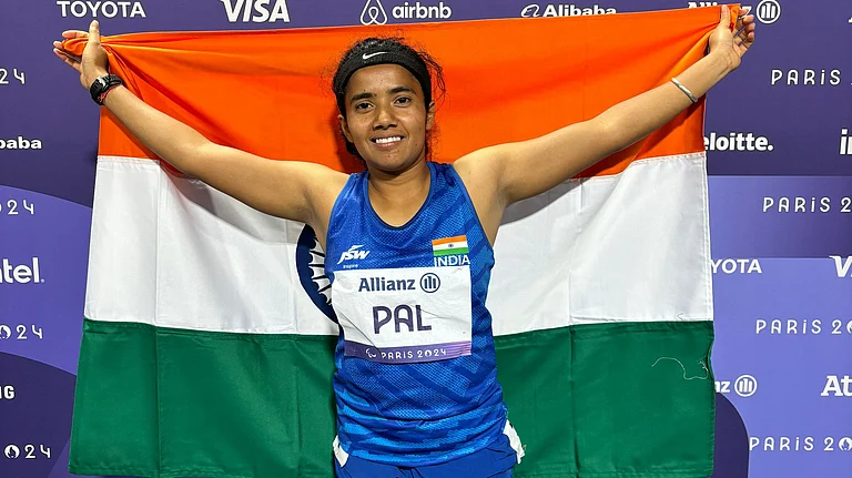 India's Preethi Pal poses with the flag after clinching bronze in the 100m event. - PCI